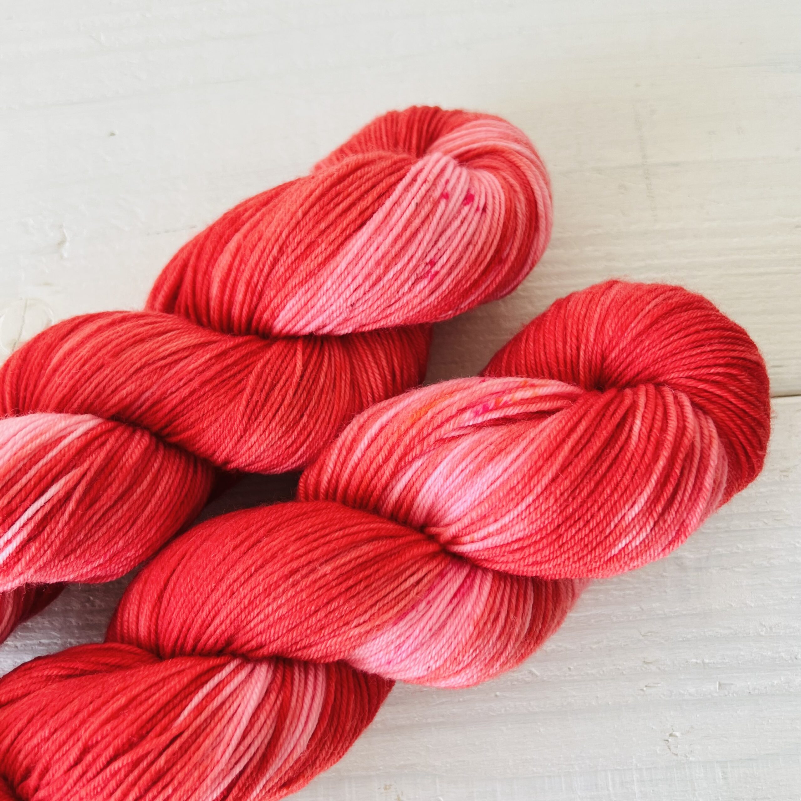 赤とピンクの手染め毛糸のスペックルやグラデーションが見えるアップ