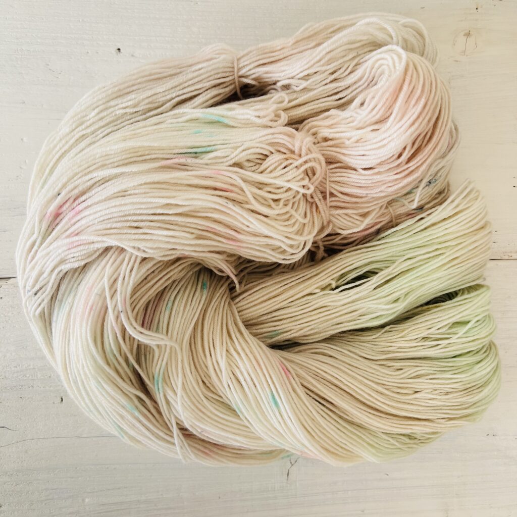 ピンクやイエローグリーングラデーションの手染め毛糸のカセをほどいた色の入り方