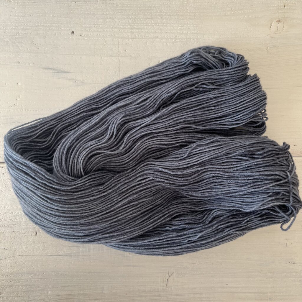 くすんだ紺色の手染め毛糸のカセをほどいた色の入り方