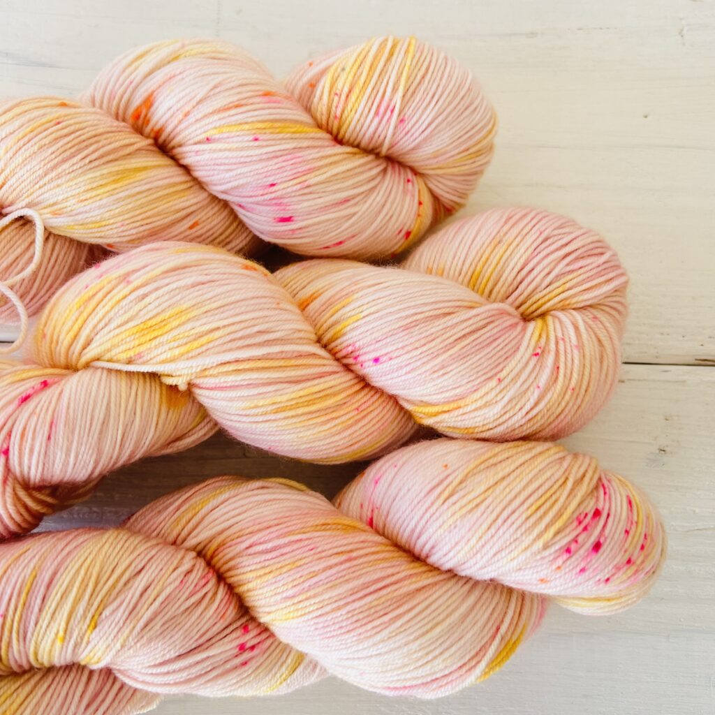 ピーチカラー手染め毛糸のスペックルやグラデーションが見えるアップ