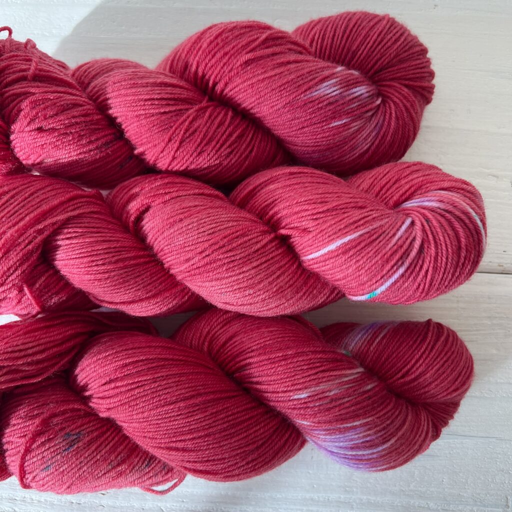 濃い赤の手染め毛糸のスペックルや抜染が見えるアップ