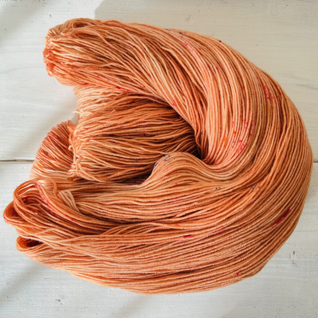 赤みオレンジの手染め毛糸のカセをほどいた色の入り方