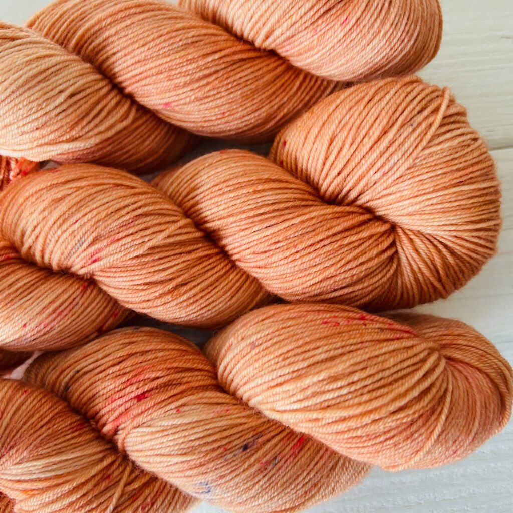 キャラメルオレンジ色の手染め毛糸のスペックルやグラデーションが見えるアップ