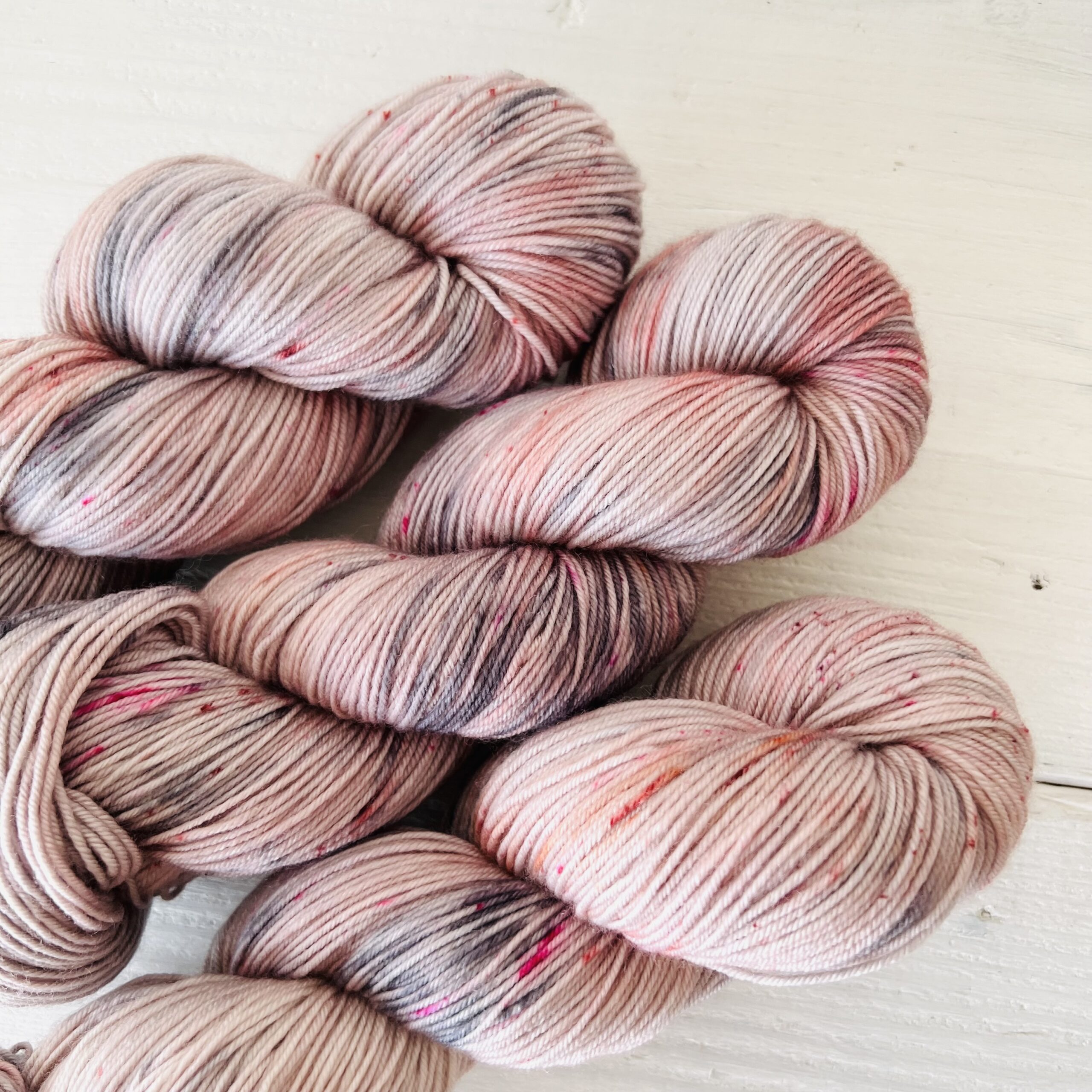 ピンクグレーの手染め毛糸のスペックルやグラデーションが見えるアップ