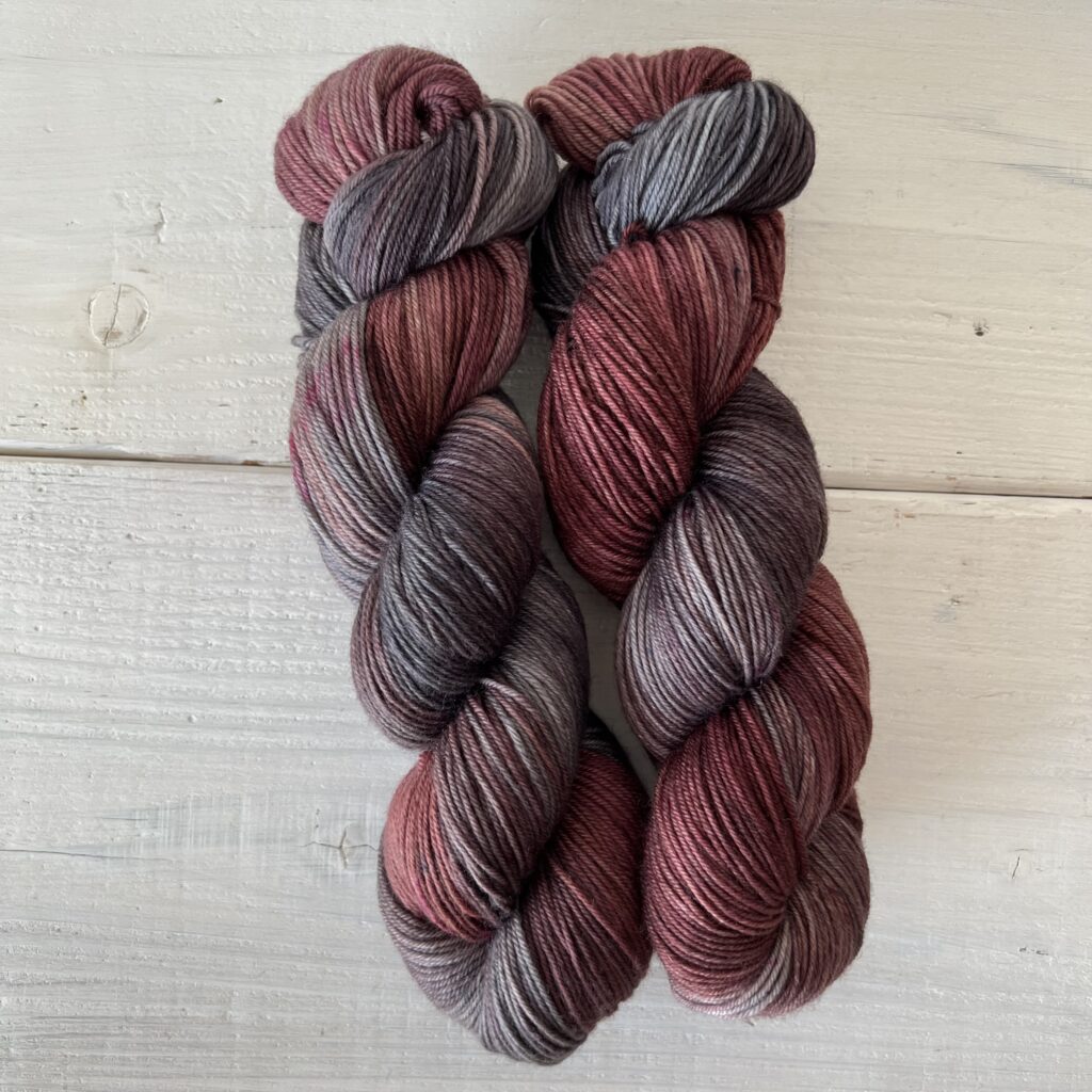 濃い赤とダークグレーの手染め毛糸のカセ全体