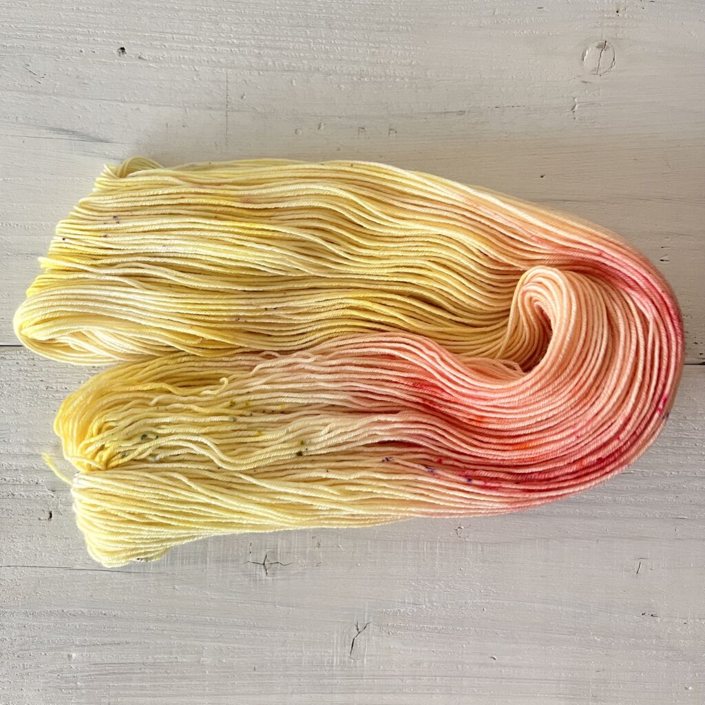 イエローやオレンジグラデーションの手染め毛糸のカセをほどいた色の入り方