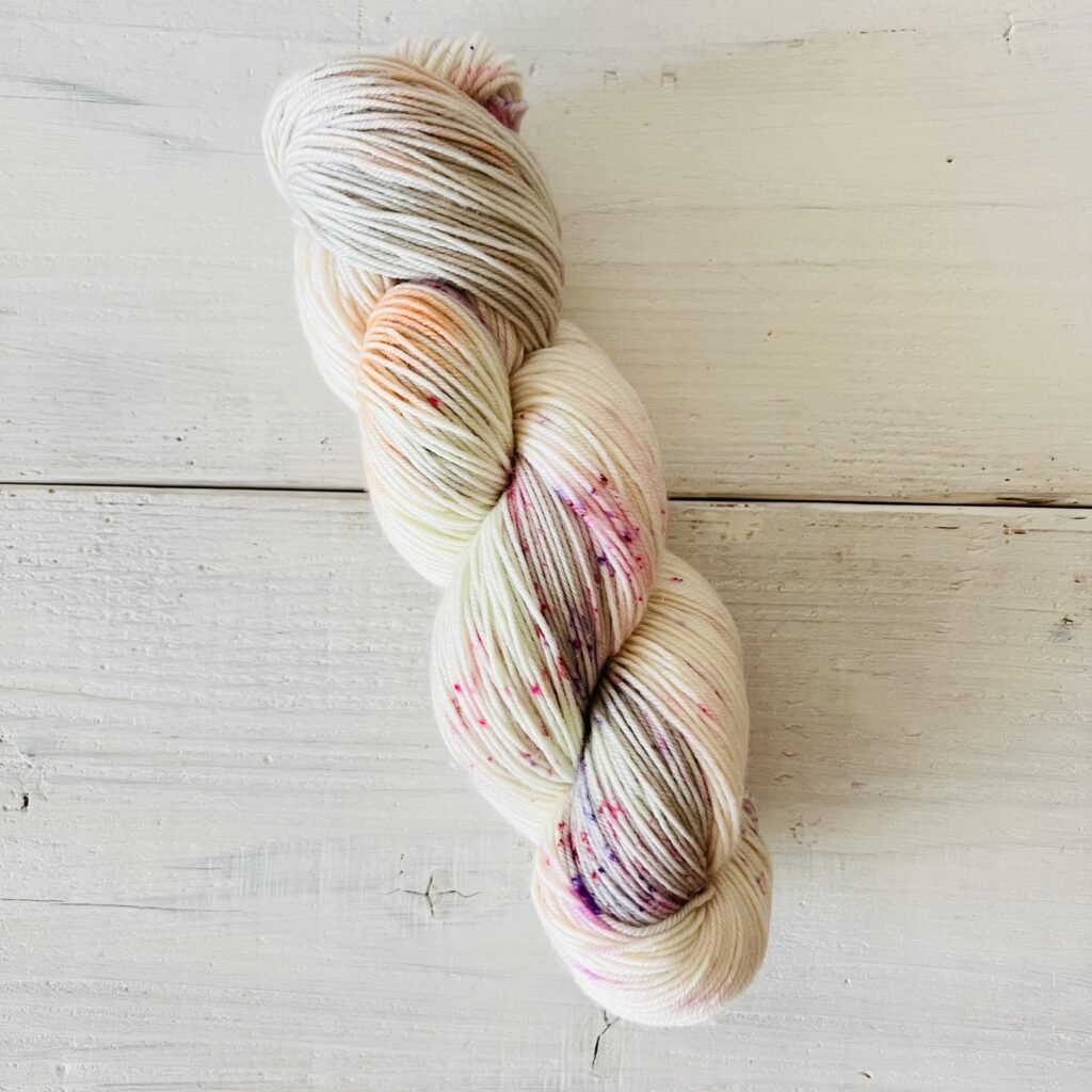 グレイッシュなホワイトベースにキャンディーカラーの手染め毛糸のカセ全体