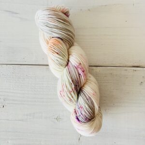 グレイッシュなホワイトベースにキャンディーカラーの手染め毛糸のカセ全体