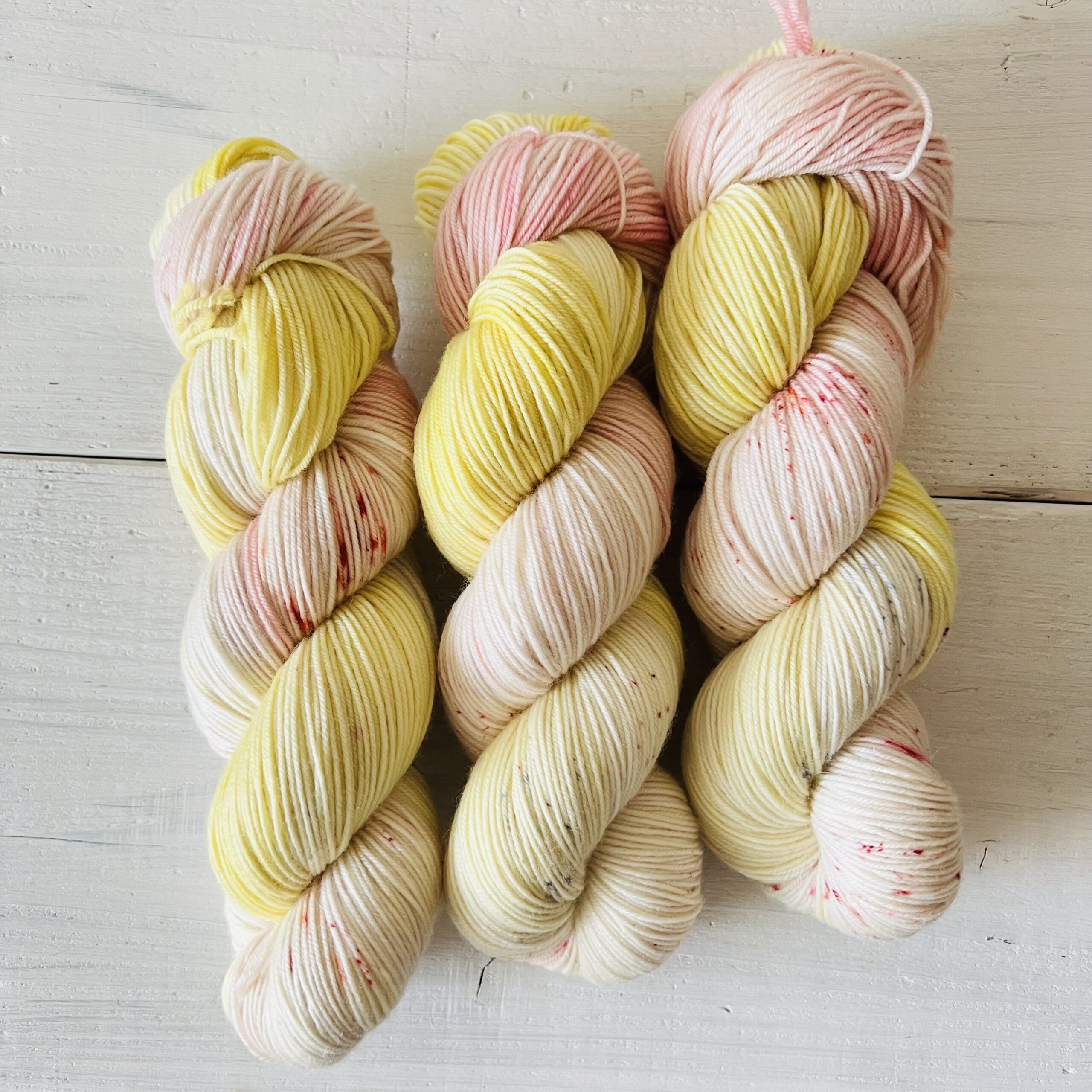 パステルイエローピンクカラーの手染め毛糸のカセ全体