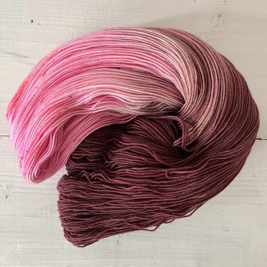 マゼンタピンクやモーブピンクグラデーションの手染め毛糸のカセをほどいた色の入り方