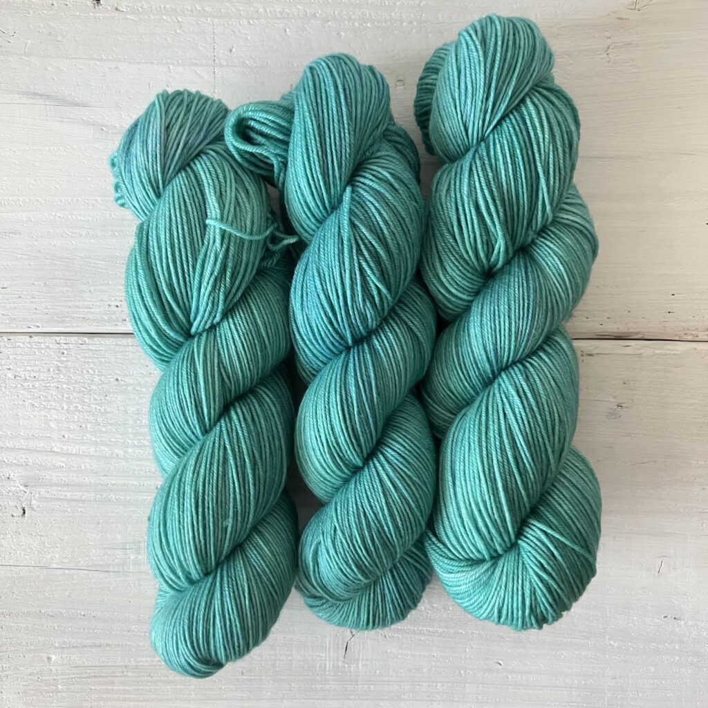 ブルーがオーバーレイされたティールグリーンの手染め毛糸のカセ全体