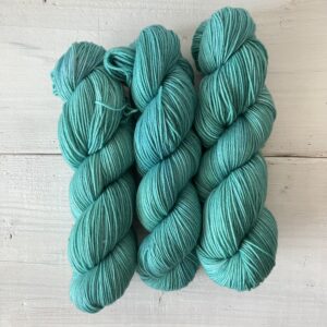 ブルーがオーバーレイされたティールグリーンの手染め毛糸のカセ全体