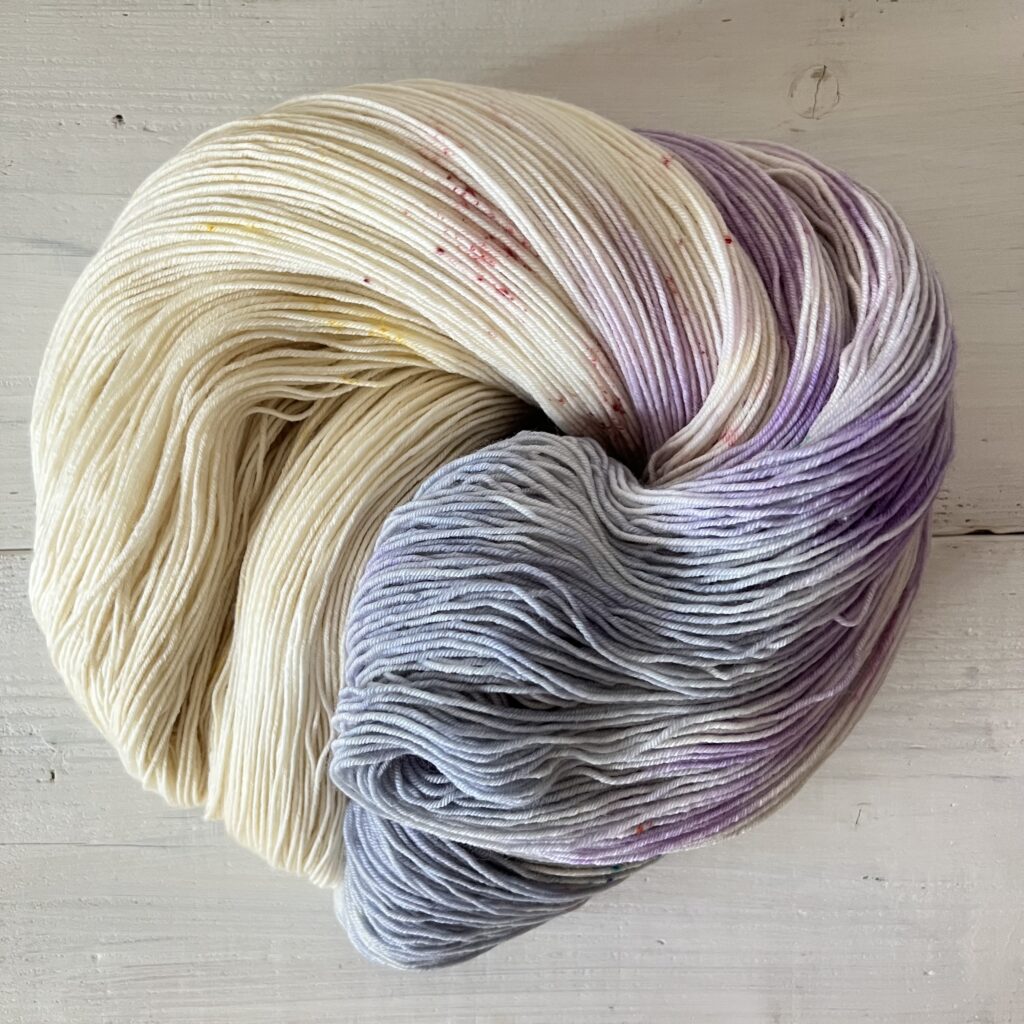 アイボリーとパープルとソフトブルーグラデーションの手染め毛糸のカセをほどいた色の入り方