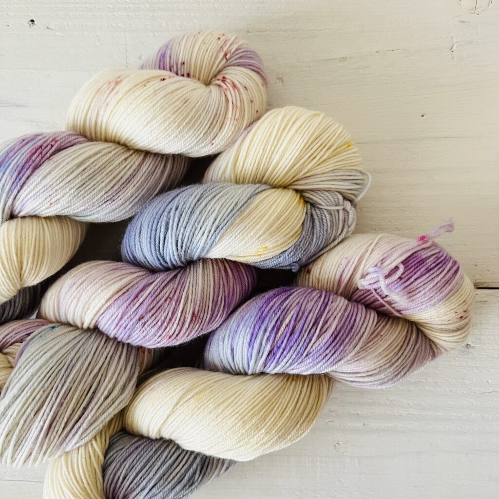 パステルパープルとパウダーブル手染め毛糸のスペックルやグラデーションが見えるアップ