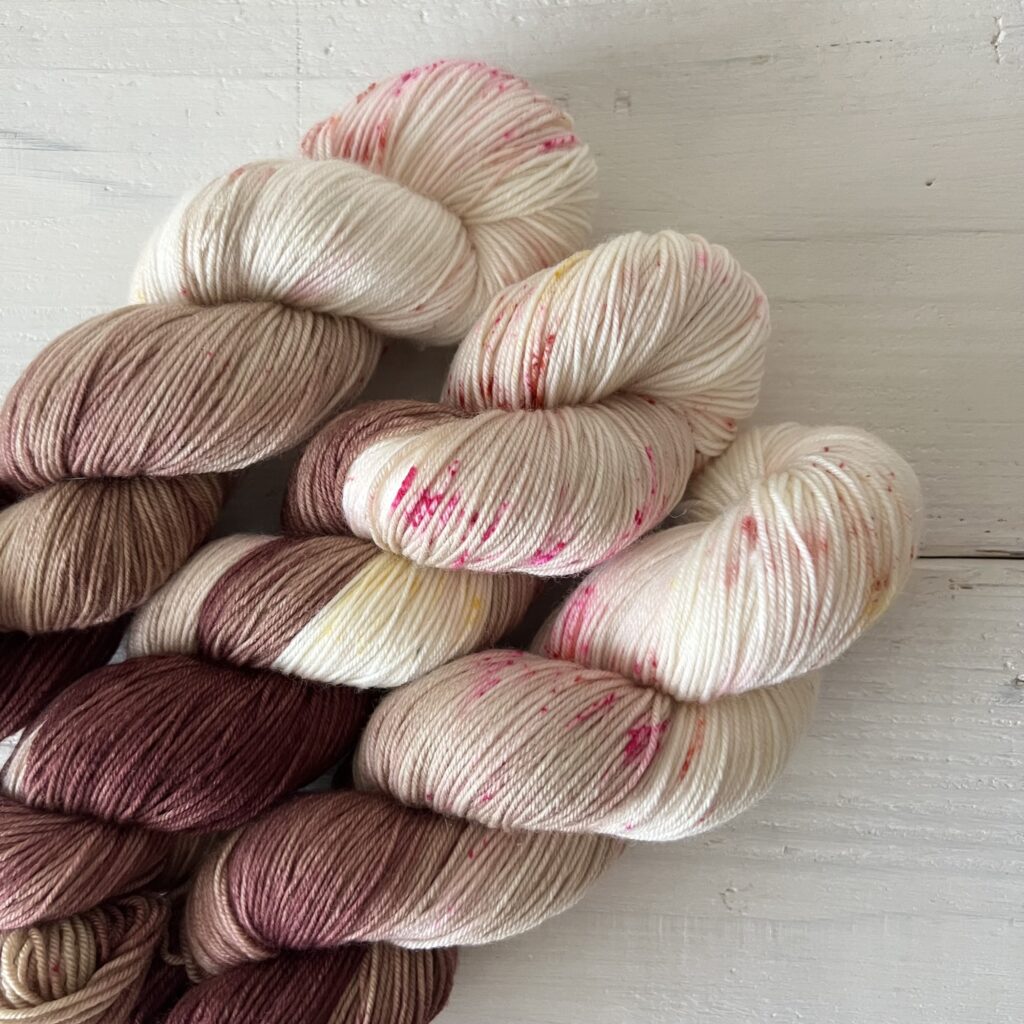 赤みをおびたモーブブラウン手染め毛糸のスペックルやグラデーションが見えるアップ