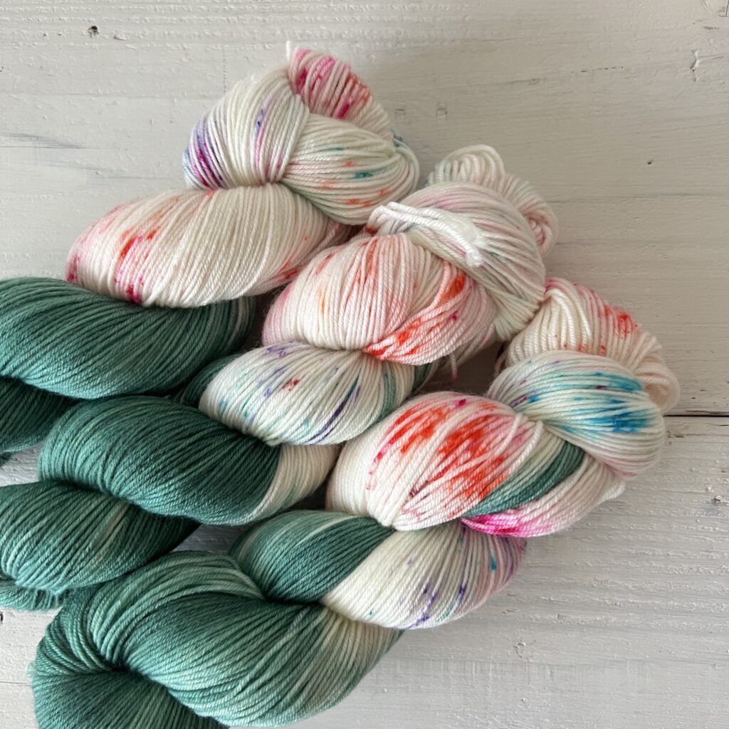 ヒスイ色の手染め毛糸のカラフルなスペックルやグラデーションが見えるアップ