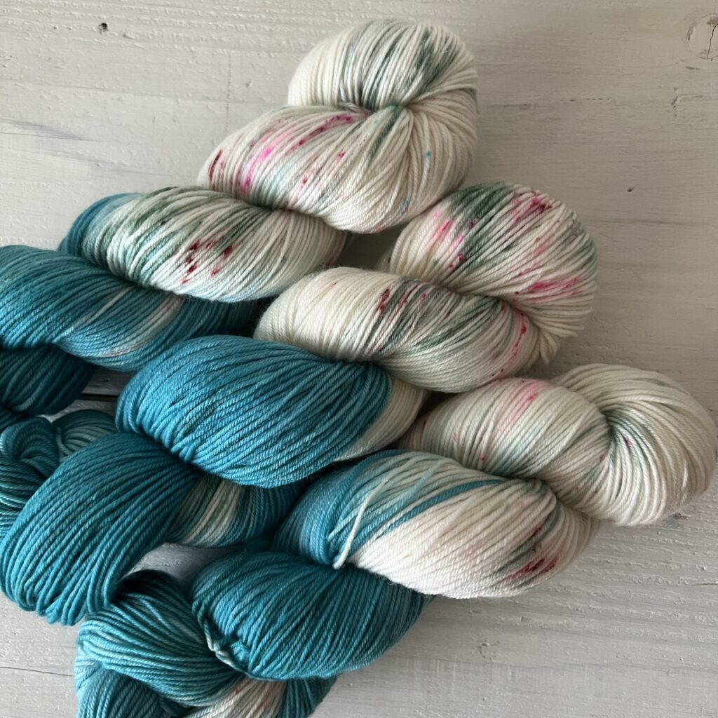 ブルーグリーンとアイボリー手染め毛糸のスペックルやグラデーションが見えるアップ