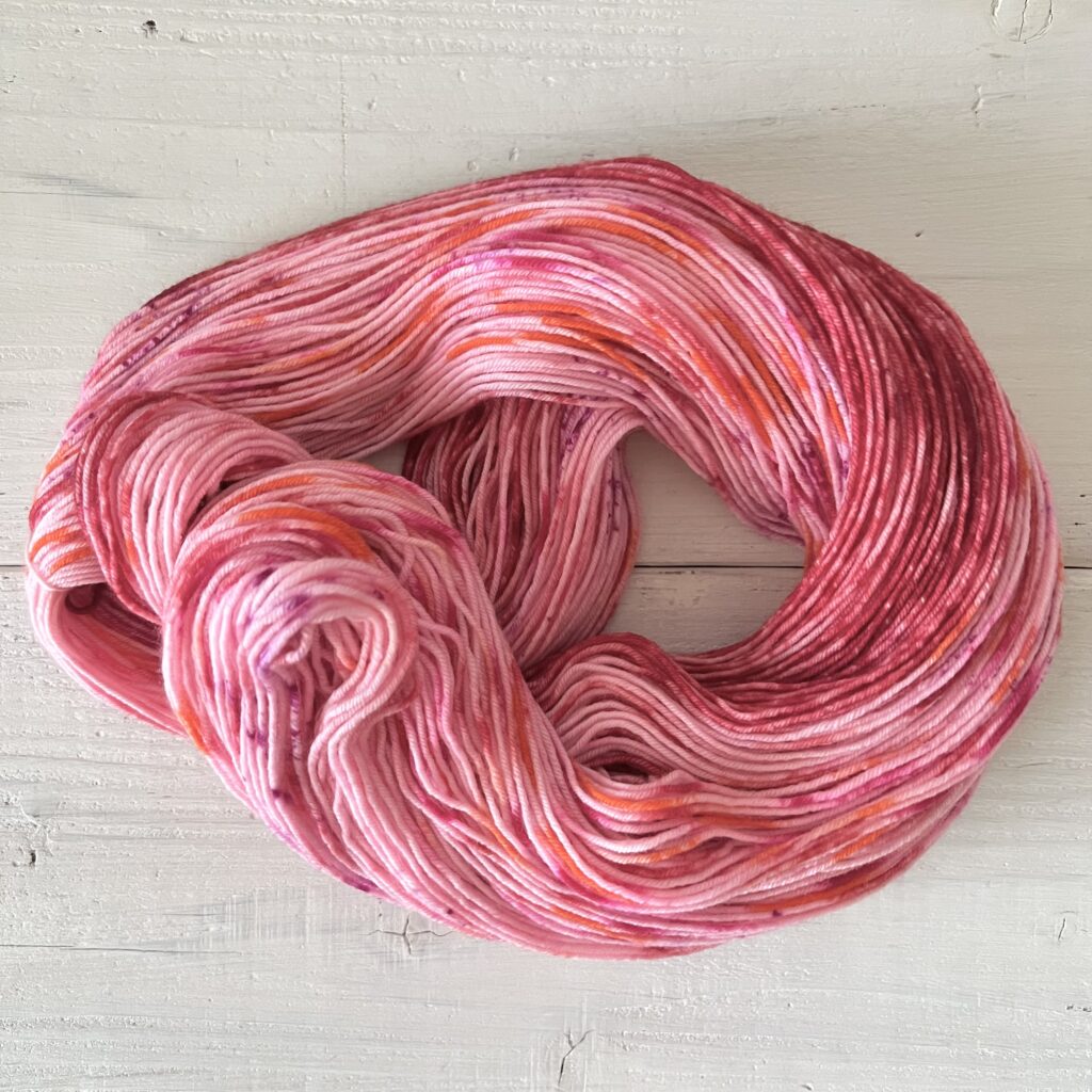 ピンクにレッド・オレンジなどの手染め毛糸のカセをほどいた色の入り方
