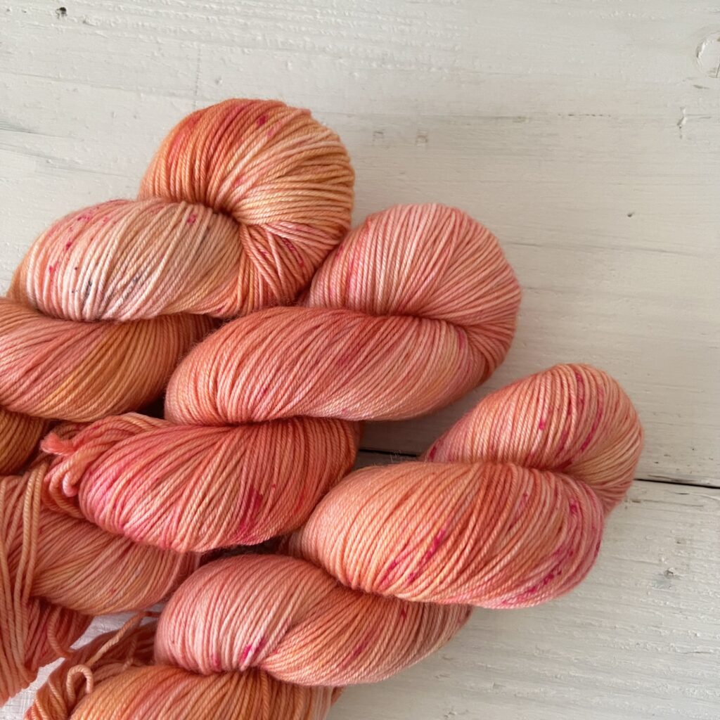 ニュアンスオレンジの手染め毛糸のスペックルやグラデーションが見えるアップ