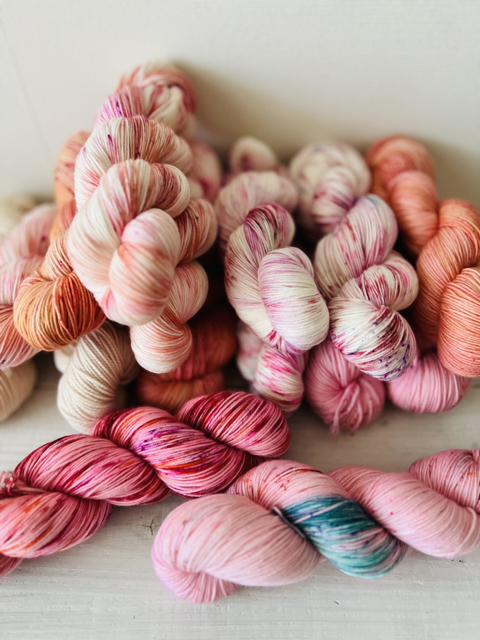 さまざまなピンクの手染め毛糸のかせ集合